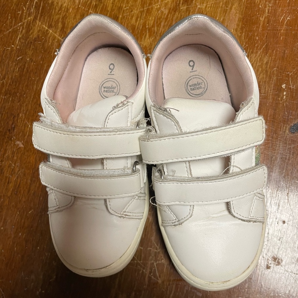 White Size Nine tennis shoes with rainbow embellishment.